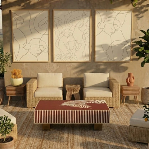 Outdoor patio furniture set with wicker chairs, table, and cushions in a sunlit room.