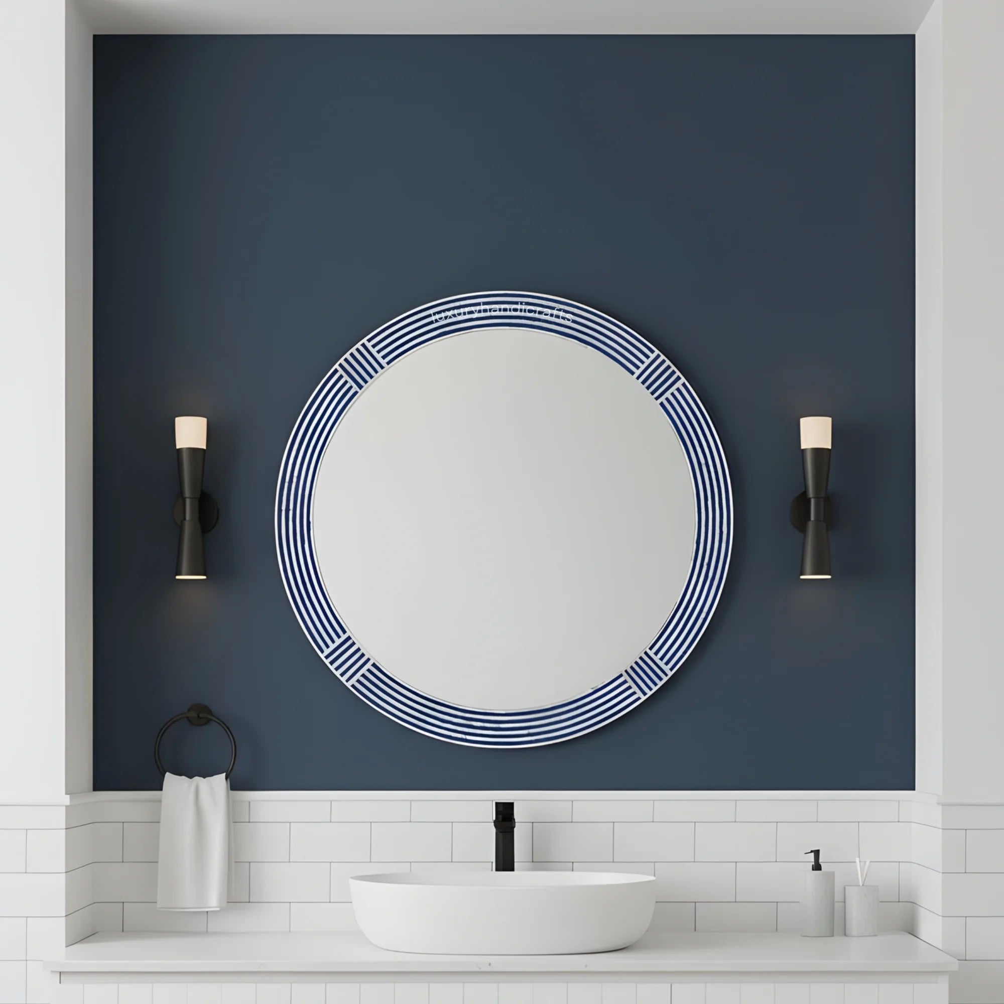 Round mirror with decorative frame on a blue wall above a white sink.