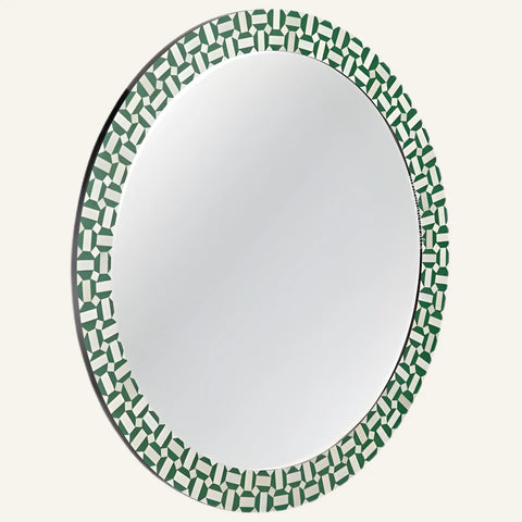 Round mirror with a green and white geometric pattern on a white background