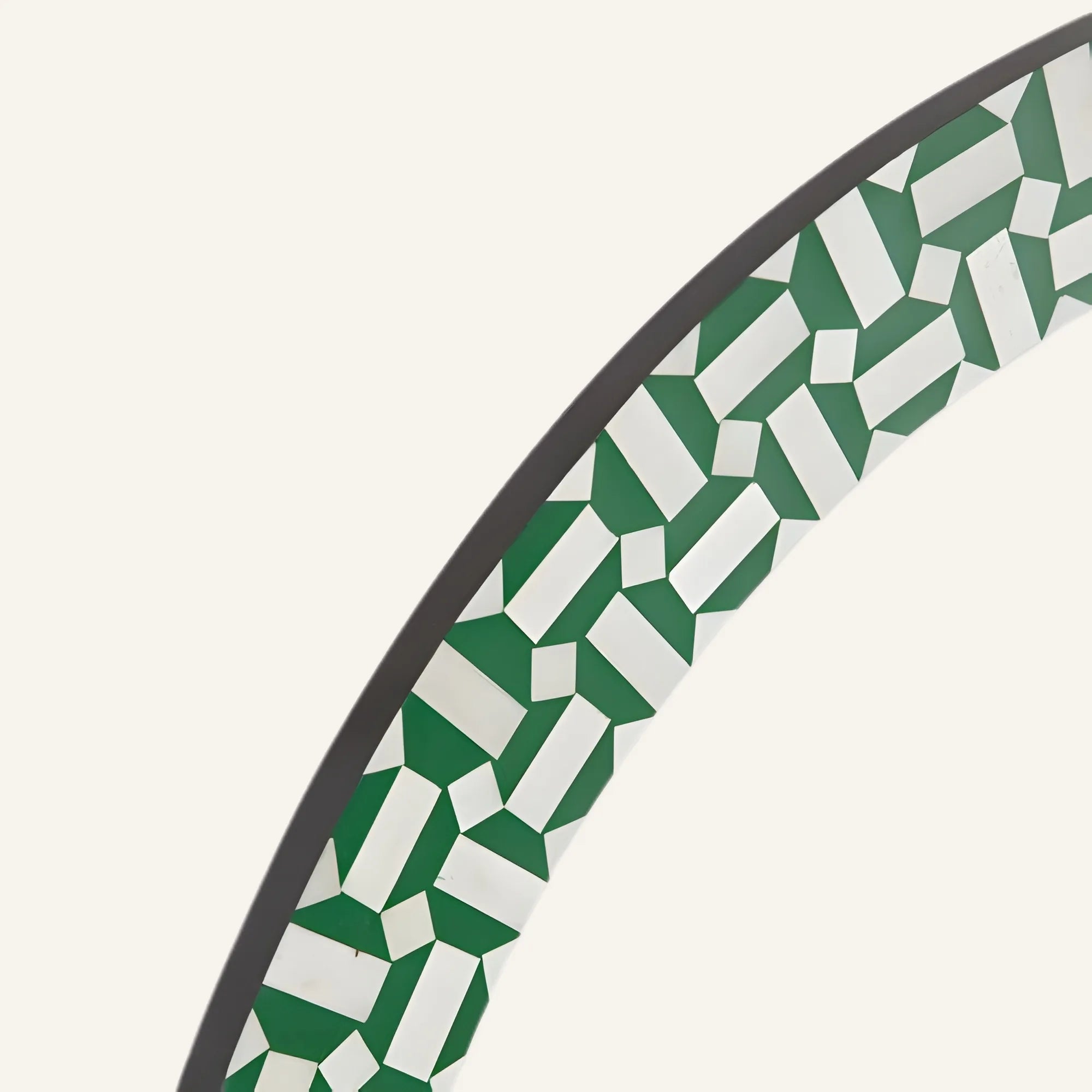 Close-up of a circular object with green and white geometric pattern on a white background