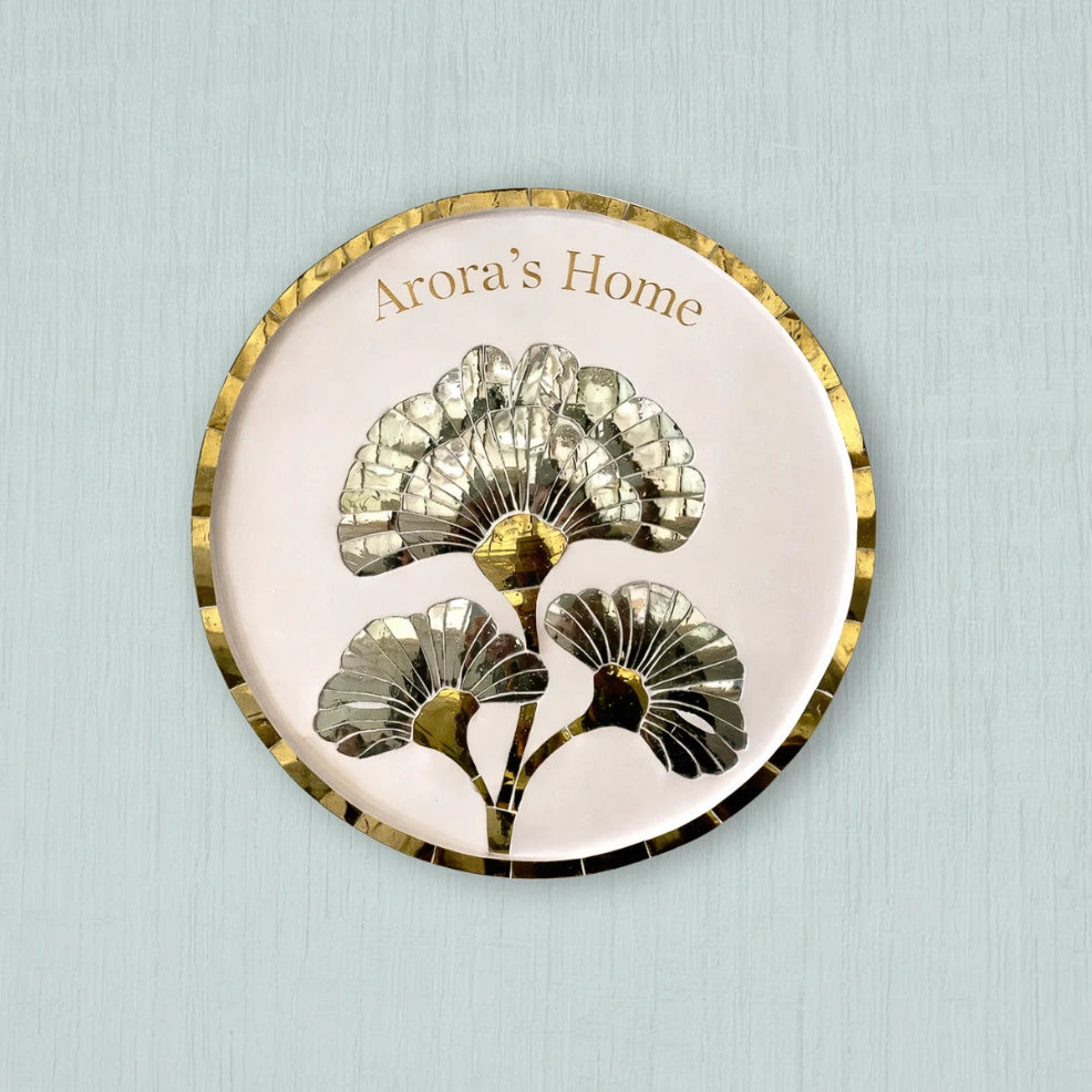 Decorative plate with floral design and 'Arora's Home' text on a light blue background