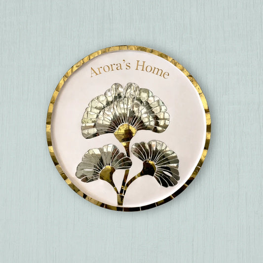 Decorative plate with floral design and 'Arora's Home' text on a light blue background