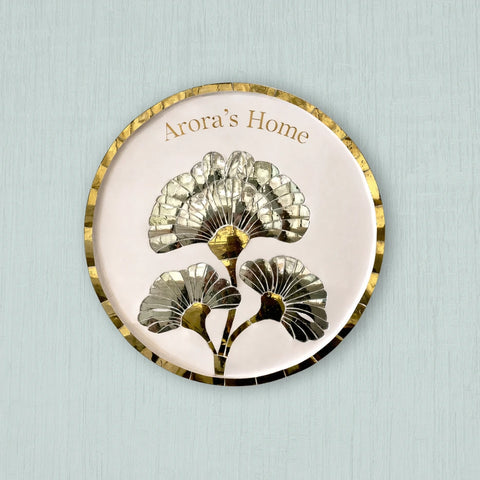 Decorative plate with floral design and 'Arora's Home' text on a light blue background