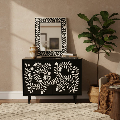 A black cabinet with bone inlay floral design, featuring two doors and a mirror with a floral pattern on the cabinet doors.