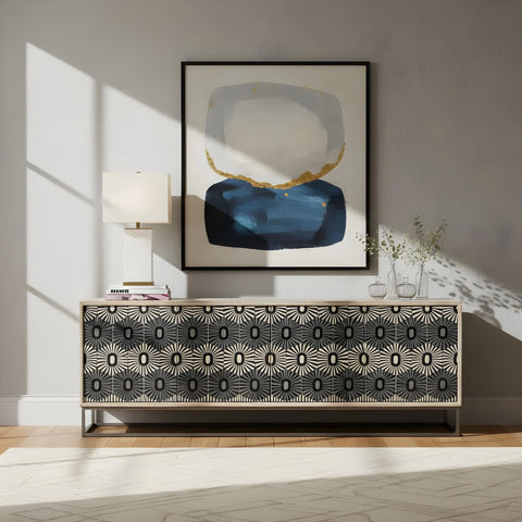 Modern interior with a patterned sideboard, abstract art, and lamp.