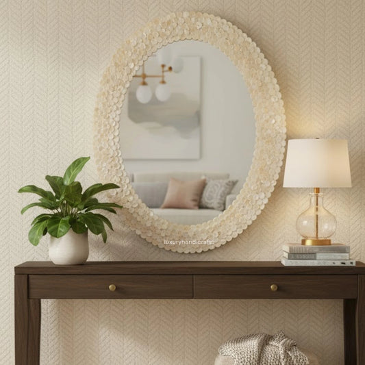 Decorative mirror with floral frame on a wall above a wooden console table.