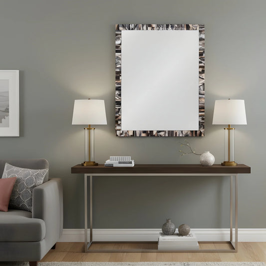Modern living room with a console table, lamps, and decorative items against a gray wall.