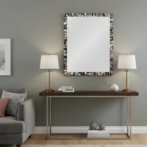Modern living room with a console table, lamps, and decorative items against a gray wall.