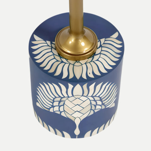 Decorative candle holder with blue base and white wing pattern on a white background