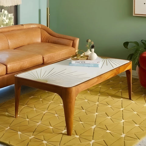 Living room with and a coffee table with decorative items on a yellow patterned rug.