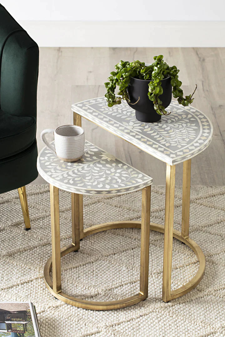 Set of two side tables with a plant and mug on a textured floor.