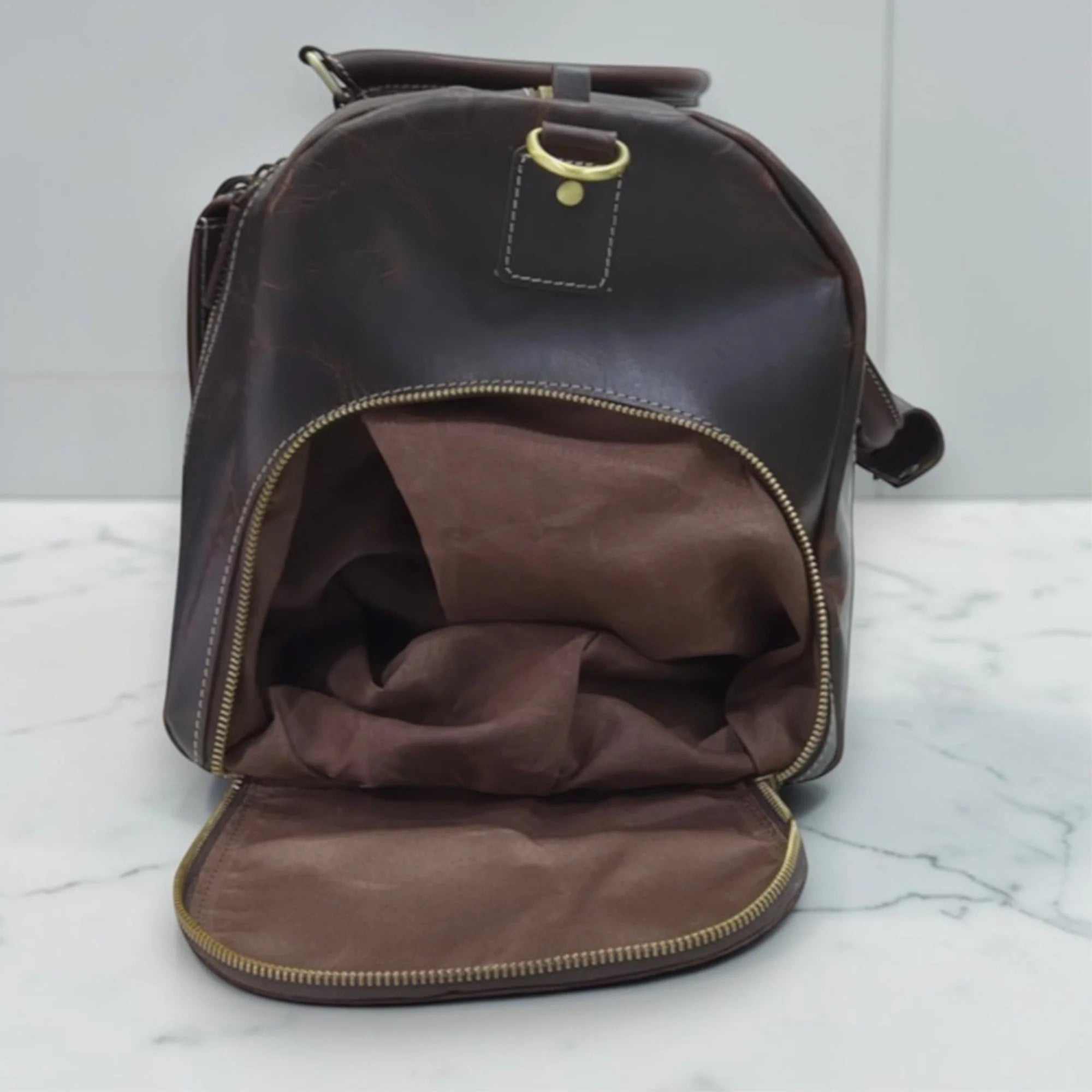 Miguel leather duffle bag opened to show the brown fabric lining inside