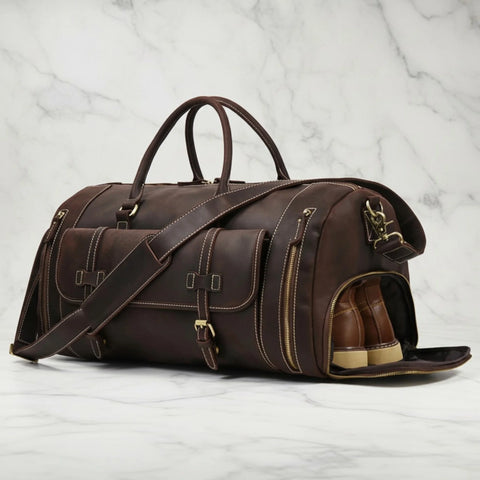 Miguel leather duffle bag with its side shoe compartment open and a pair of brown shoes inside