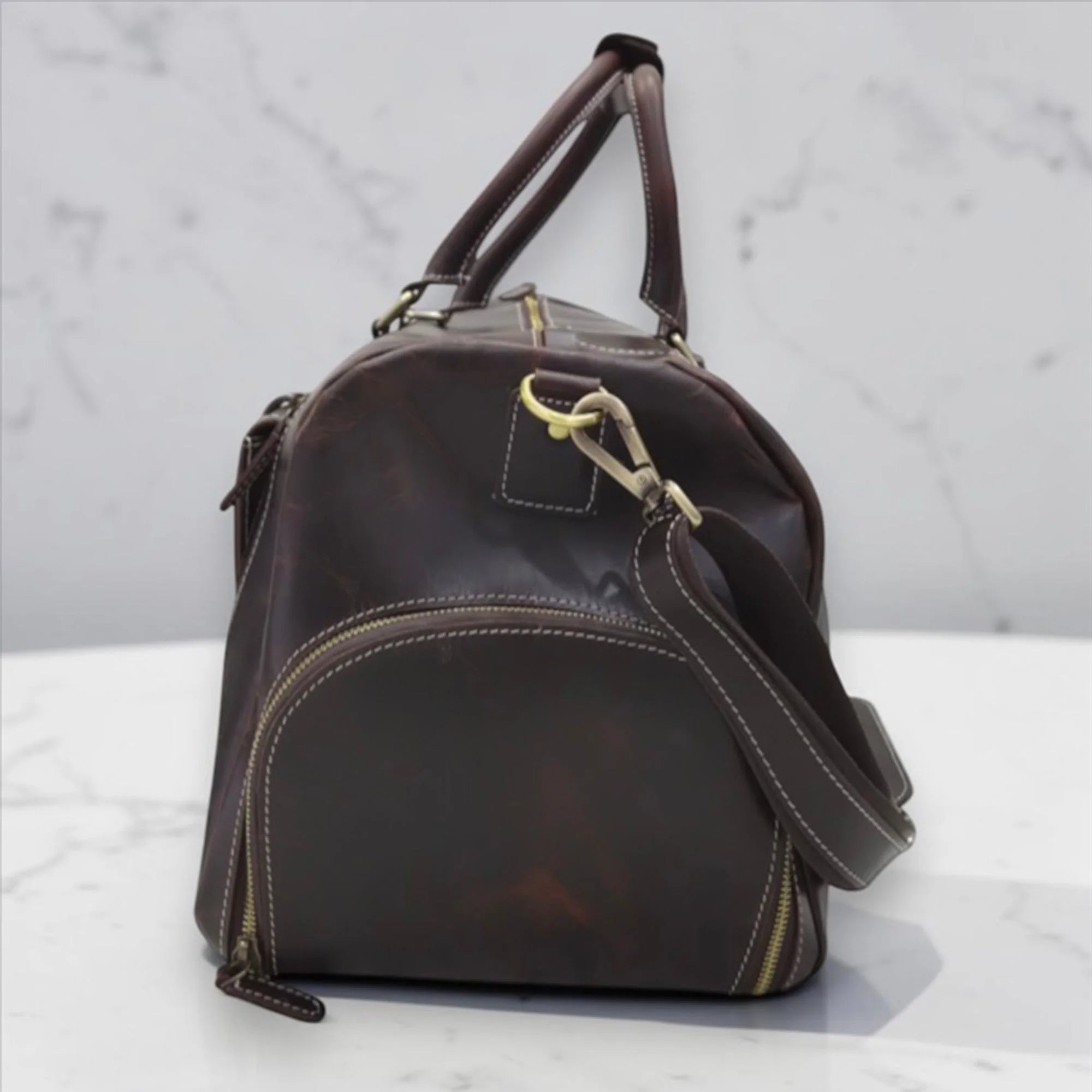 Side shoe compartment of the Miguel leather duffle bag that keeps footwear separate from clothes