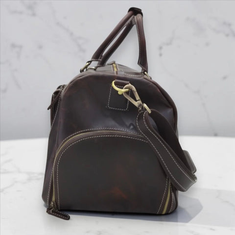 Side shoe compartment of the Miguel leather duffle bag that keeps footwear separate from clothes